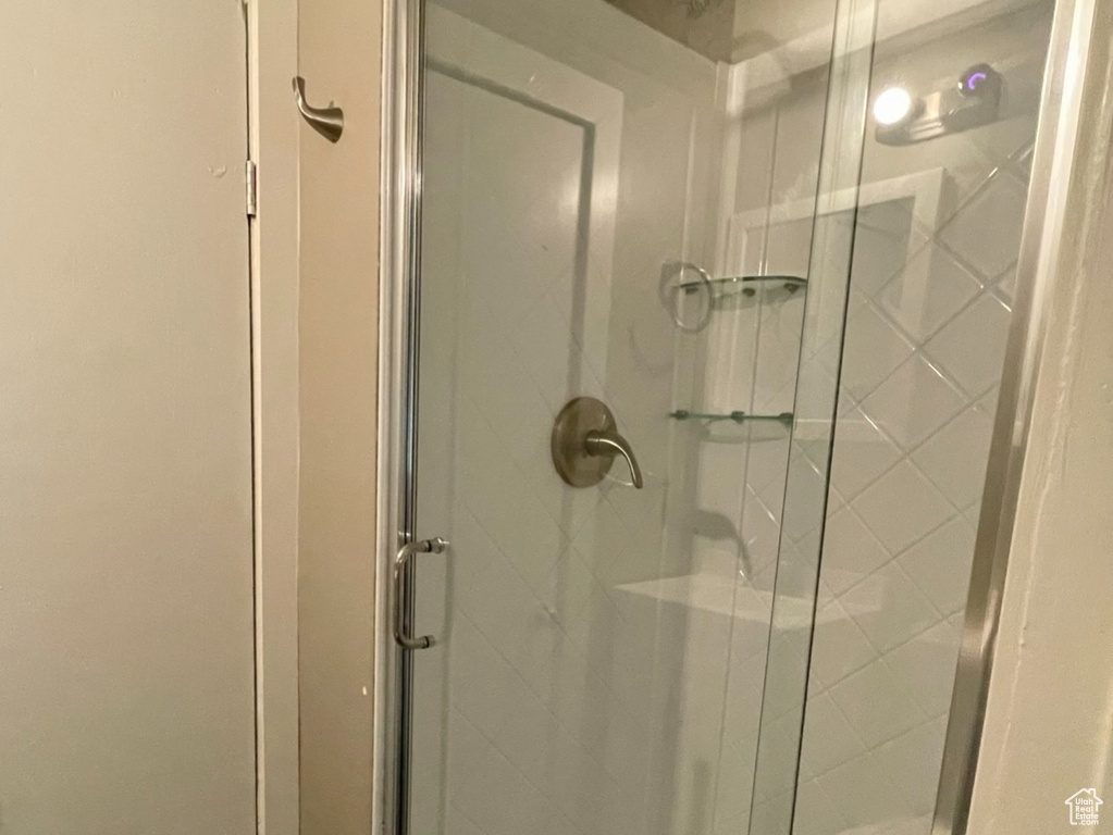 Bathroom featuring wood finished floors, a shower stall, and a textured ceiling