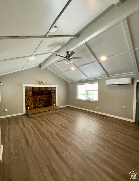 Unfurnished living room featuring a wall unit AC, baseboards, a ceiling fan, and wood finished floors