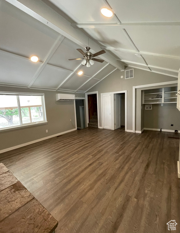 Unfurnished living room featuring ceiling fan, baseboards, dark wood-type flooring, and a wall mounted AC