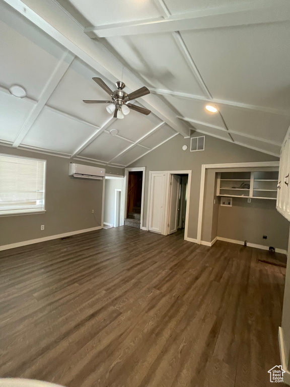 Unfurnished living room featuring a wall mounted AC, ceiling fan, baseboards, and dark wood-style floors