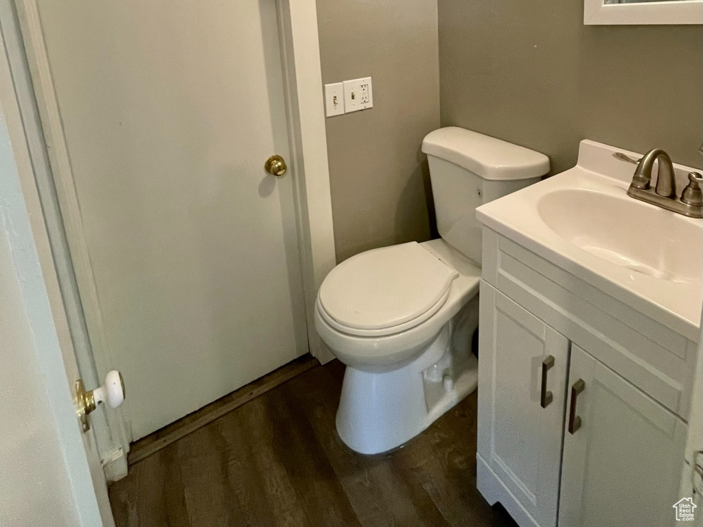 Bathroom featuring a textured ceiling, vanity, wood finished floors, toilet, and a shower