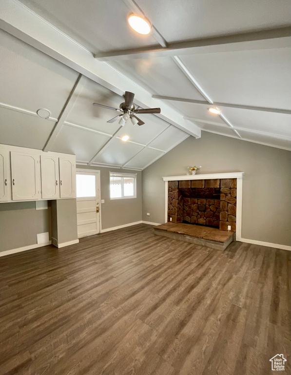 Unfurnished living room featuring baseboards, dark wood-style flooring, ceiling fan, and a fireplace