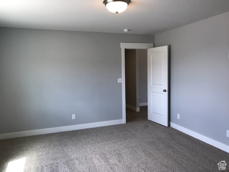 Carpeted empty room featuring baseboards