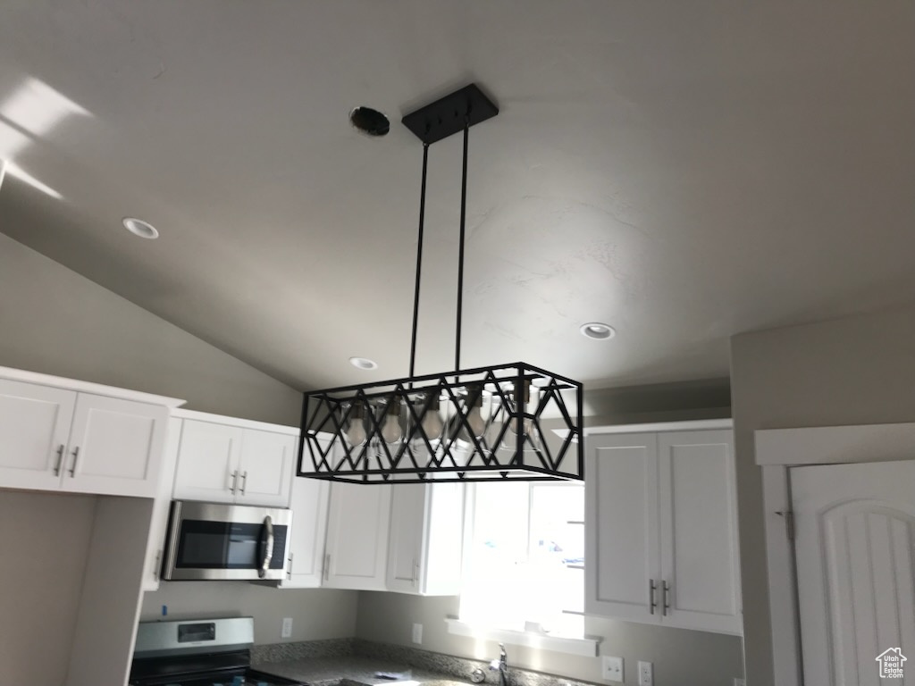 Kitchen with stainless steel appliances, recessed lighting, white cabinets, and vaulted ceiling