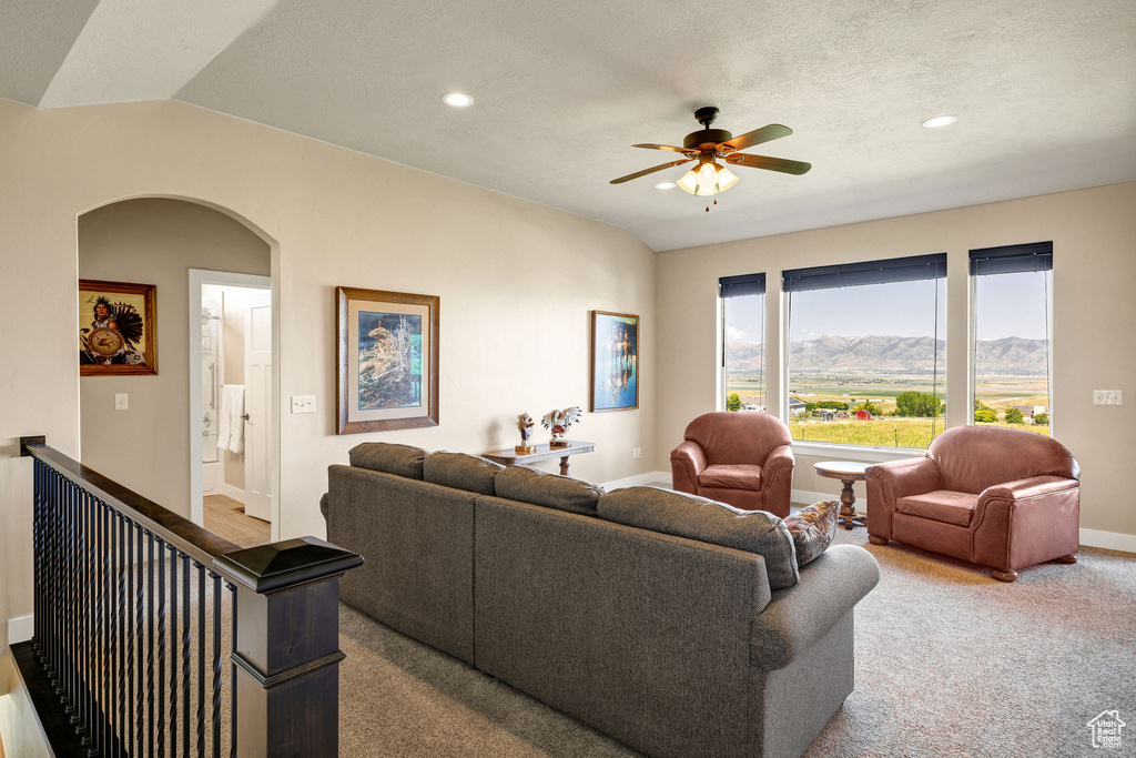 Living room with arched walkways, a ceiling fan, recessed lighting, baseboards, and carpet flooring