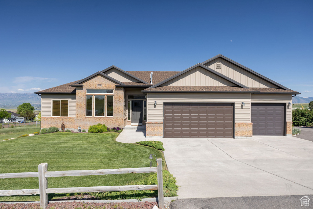 View of front facade with an attached garage, brick siding, concrete driveway, and roof with shingles