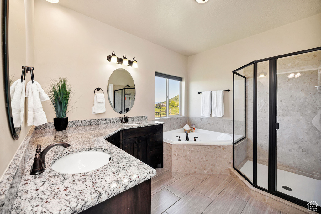 Bathroom with a garden tub, double vanity, and a shower stall