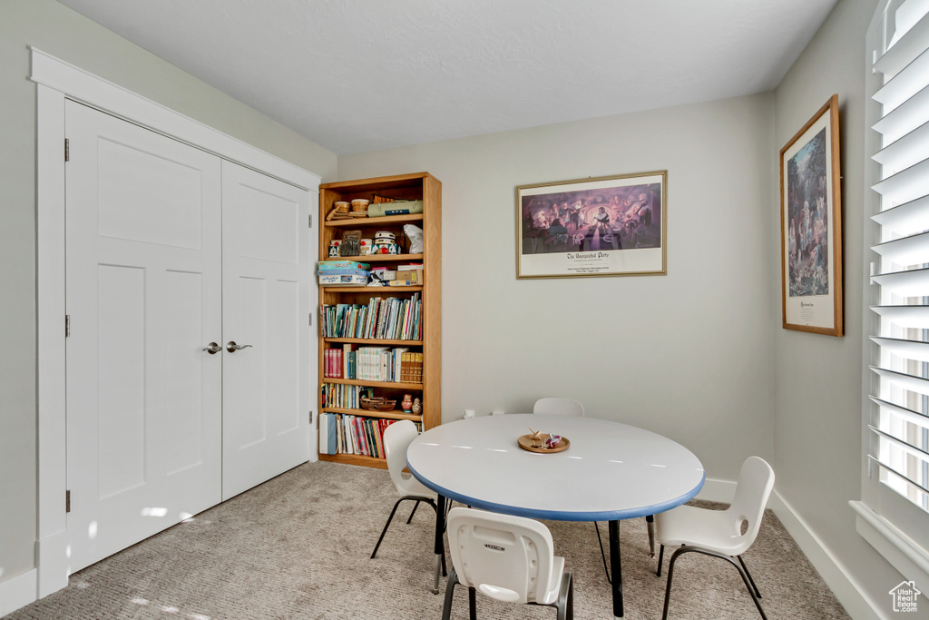 Dining area featuring light carpet and baseboards