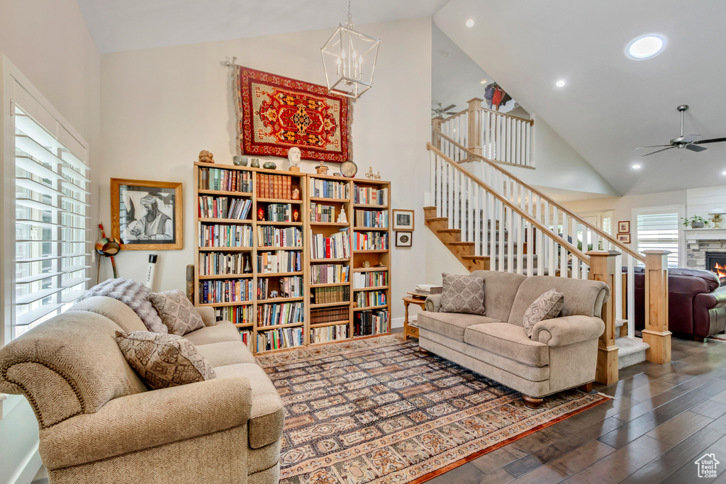Living room with high vaulted ceiling, wood finished floors, stairway, a ceiling fan, and recessed lighting
