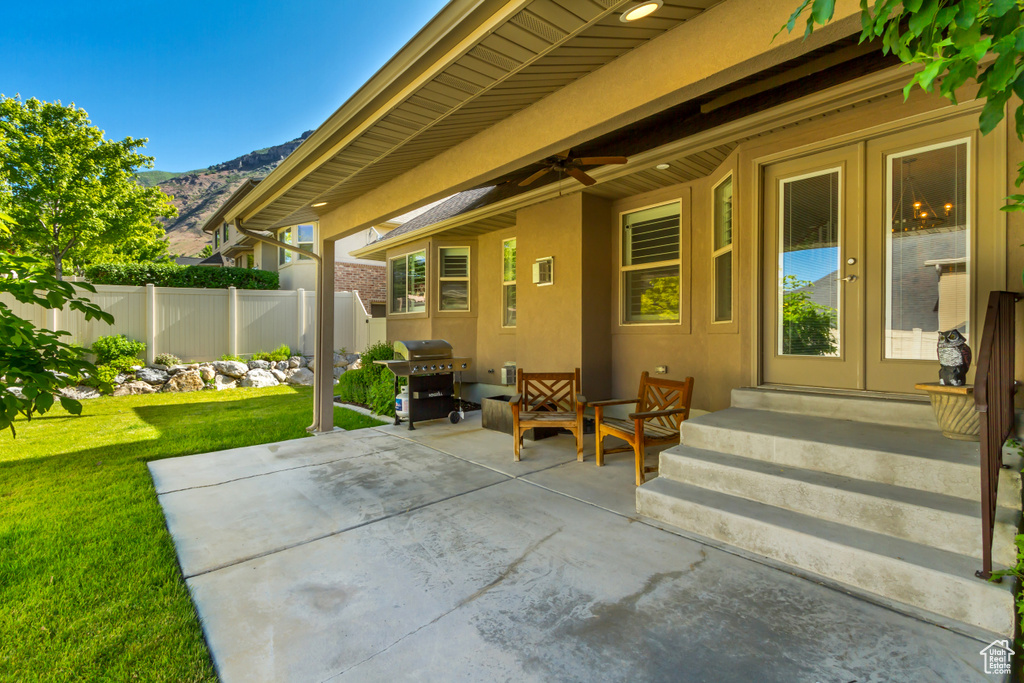 View of patio with a grill, a mountain view, entry steps, and french doors