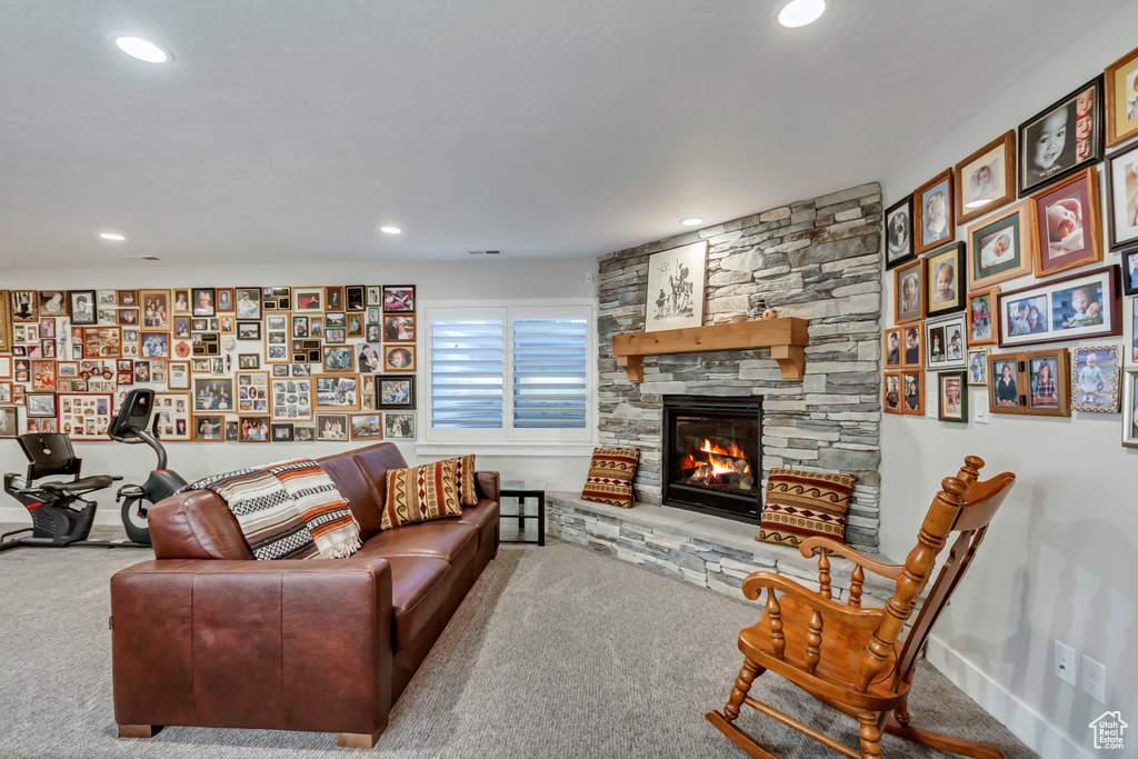 Living area with carpet floors, recessed lighting, and a fireplace