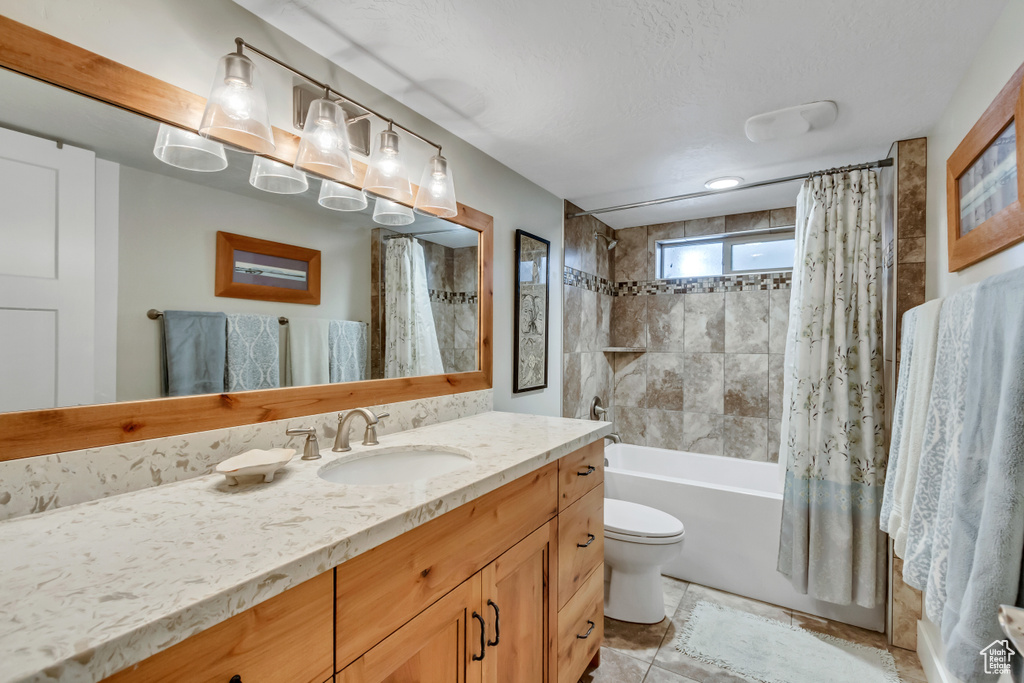 Bathroom featuring vanity, shower / tub combo, and toilet