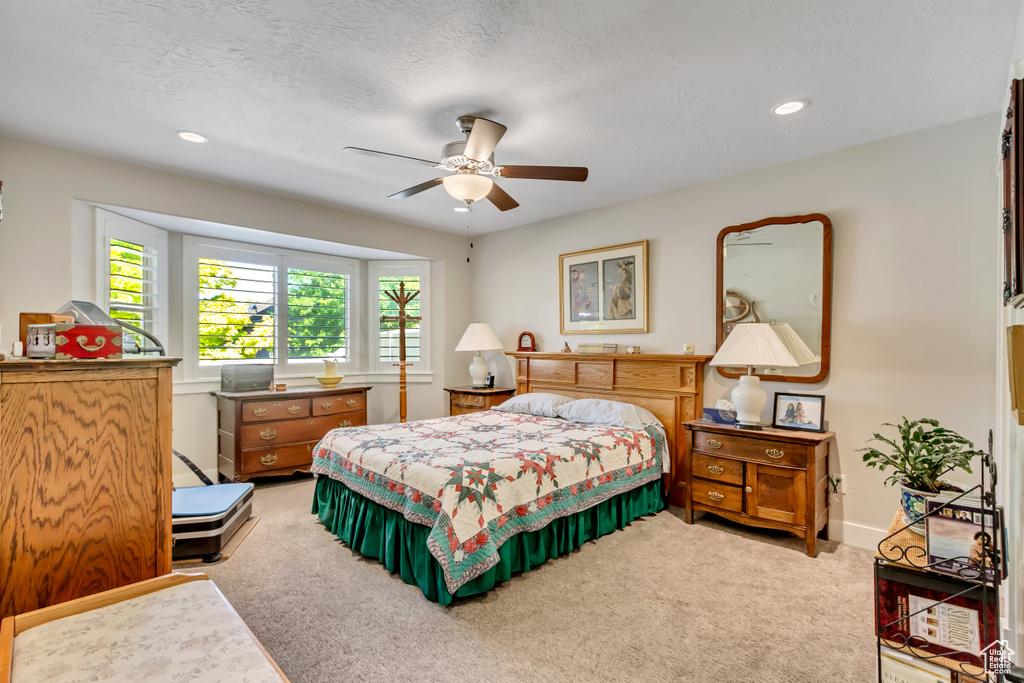 Bedroom featuring light colored carpet, recessed lighting, baseboards, a ceiling fan, and a textured ceiling