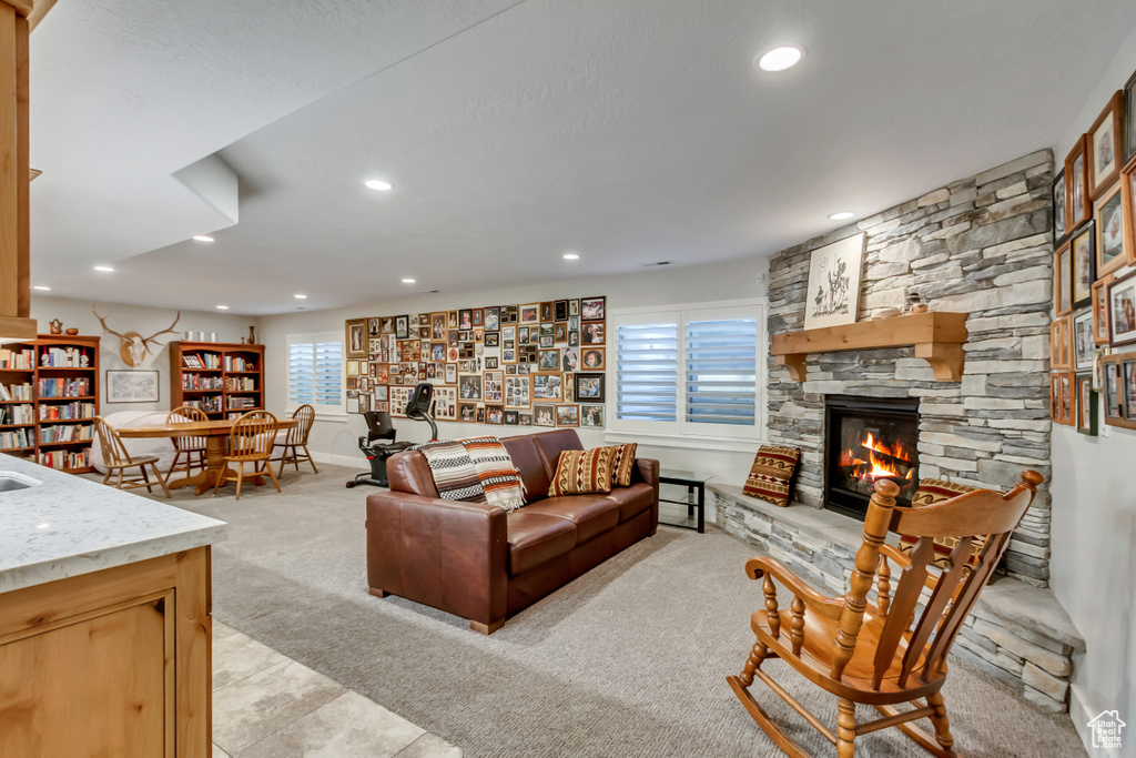 Living area with light colored carpet, a fireplace, and recessed lighting