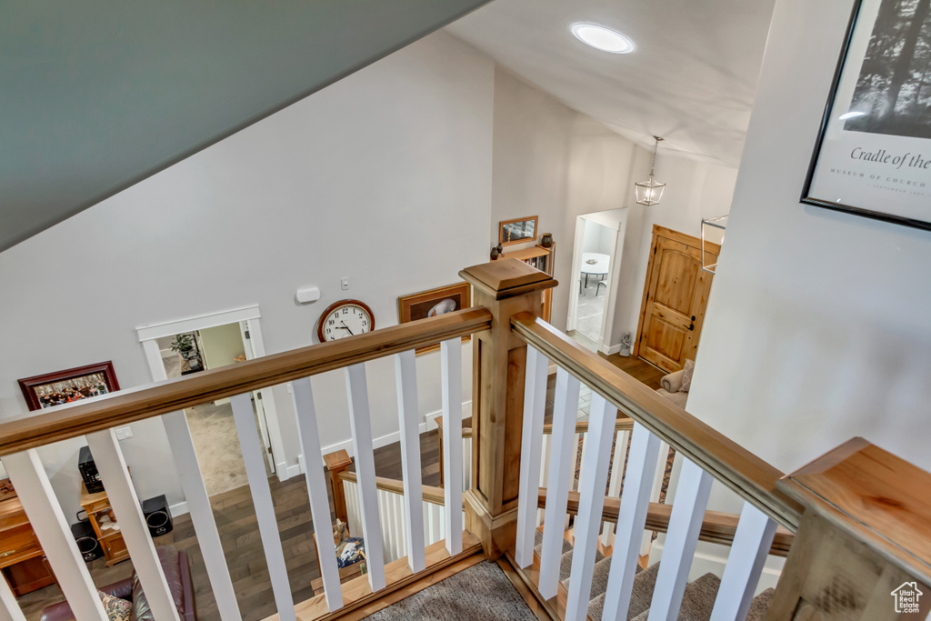 Stairway featuring high vaulted ceiling and wood finished floors