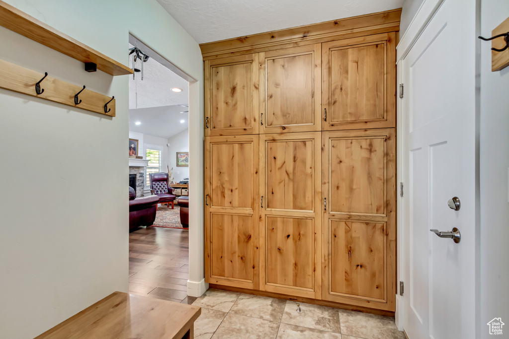 Mudroom featuring a fireplace and lofted ceiling