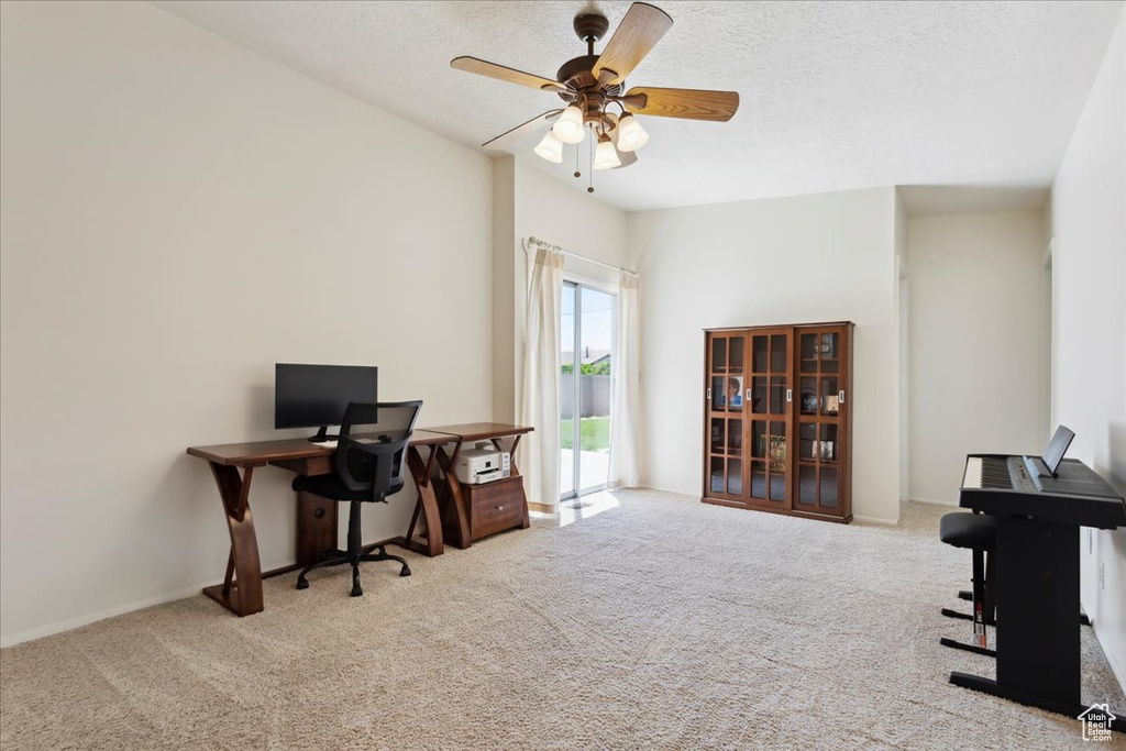 Carpeted office featuring a ceiling fan