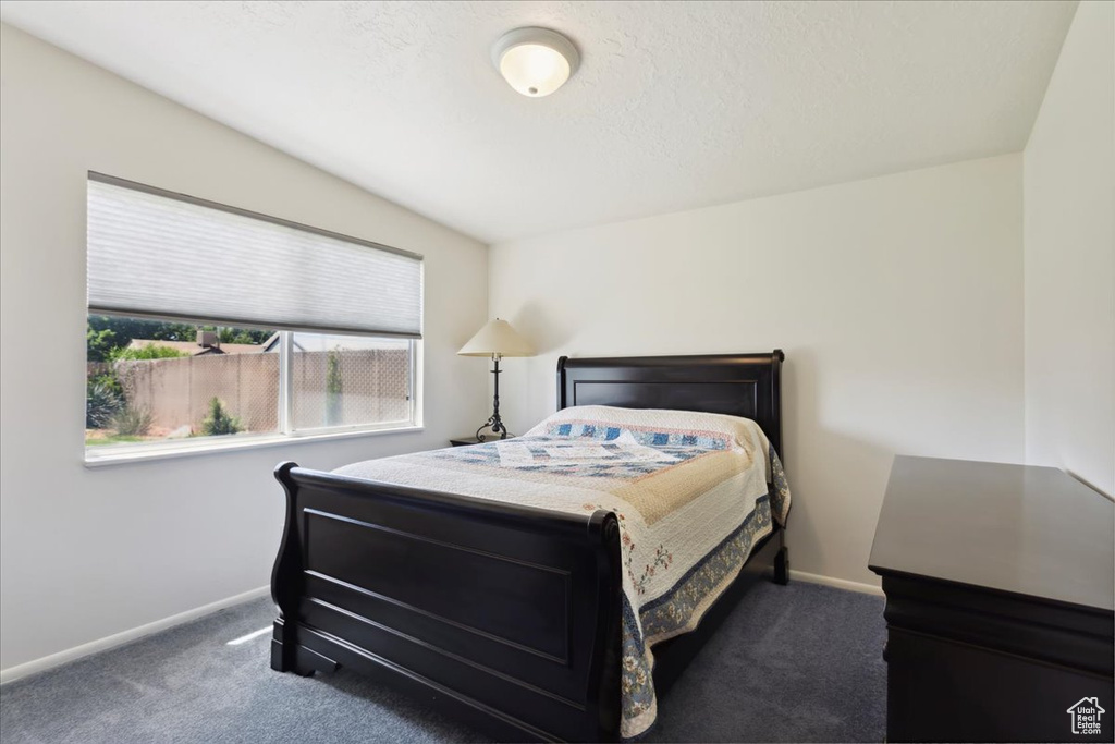 Carpeted bedroom featuring baseboards and vaulted ceiling