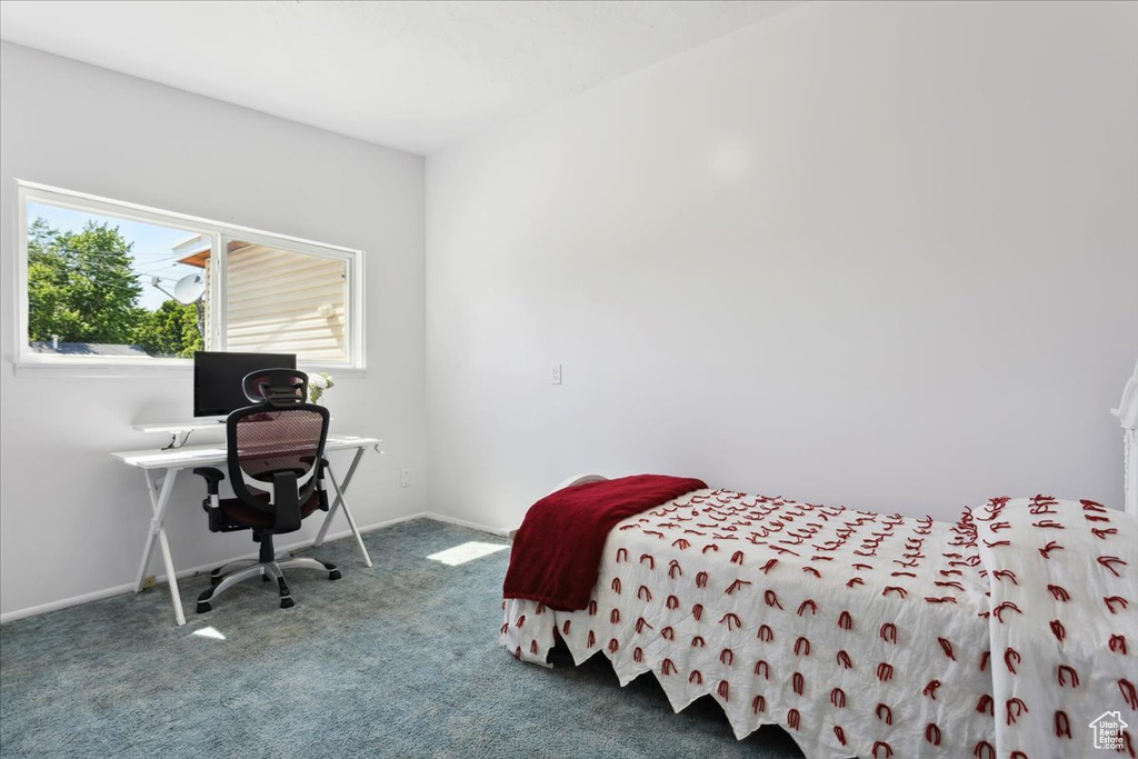 Bedroom featuring carpet and baseboards