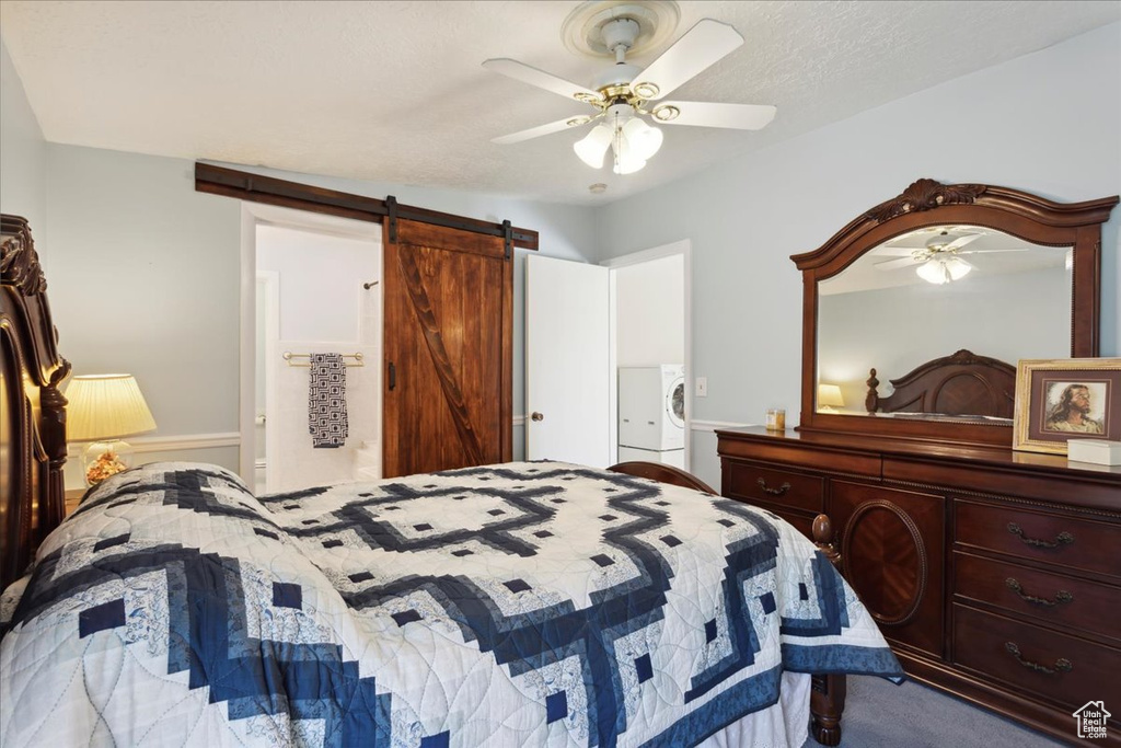 Bedroom with a barn door, washer / dryer, ceiling fan, and carpet floors