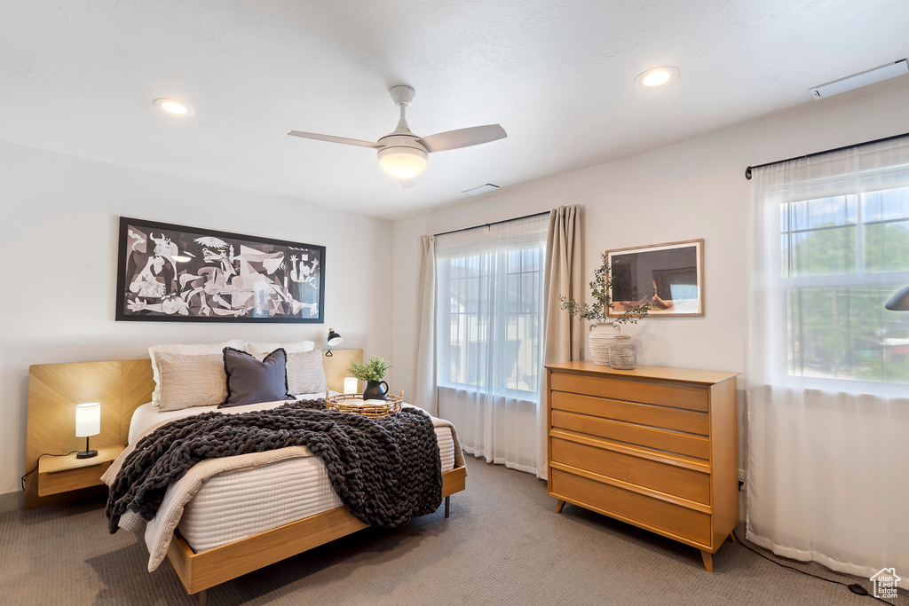 Carpeted bedroom featuring multiple windows, recessed lighting, ceiling fan, and baseboards