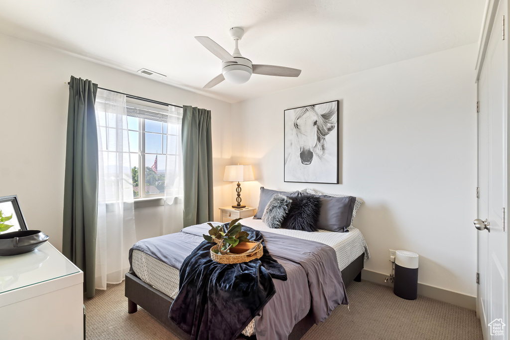 Bedroom featuring light carpet, baseboards, and ceiling fan