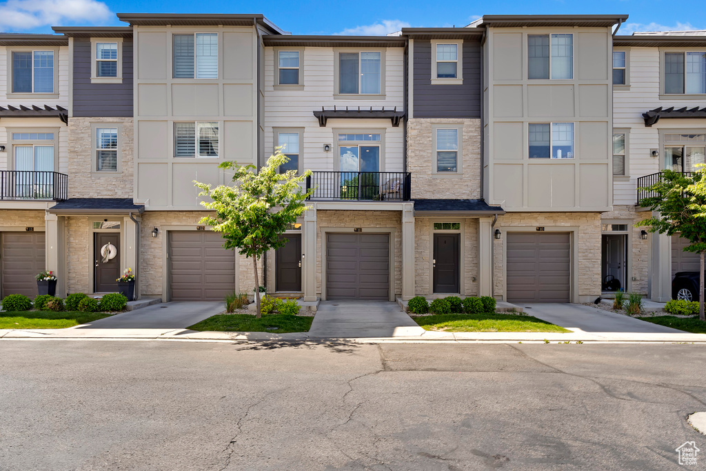 Townhome / multi-family property with an attached garage and driveway