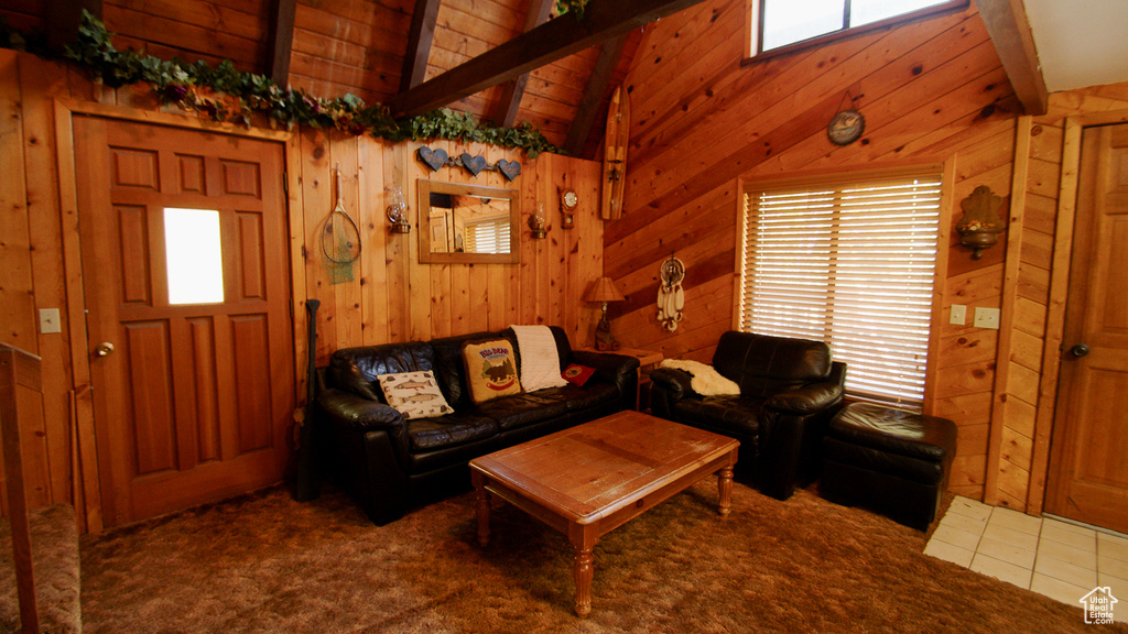 Living room with plenty of natural light, wood walls, and carpet flooring