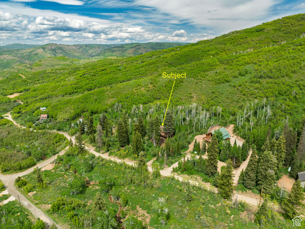 Aerial view of property and surrounding area featuring a mountainous background and property boundaries highlighted