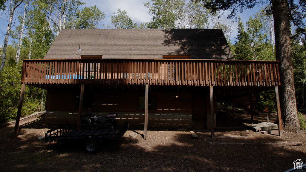 Rear view of house featuring a wooden deck and a shingled roof