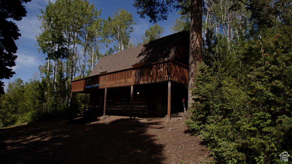 Rear view of house featuring a wooden deck and a shingled roof