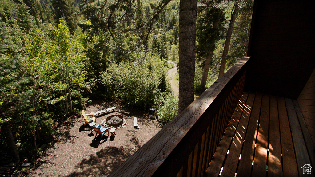 Deck featuring an outdoor fire pit and a wooded view