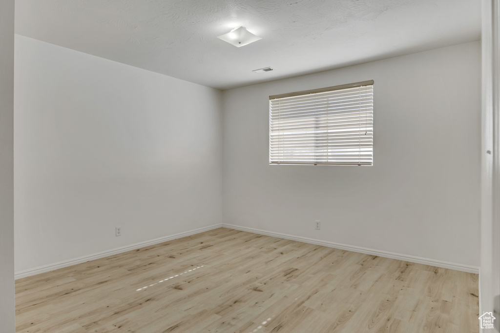 Spare room featuring wood finished floors and baseboards