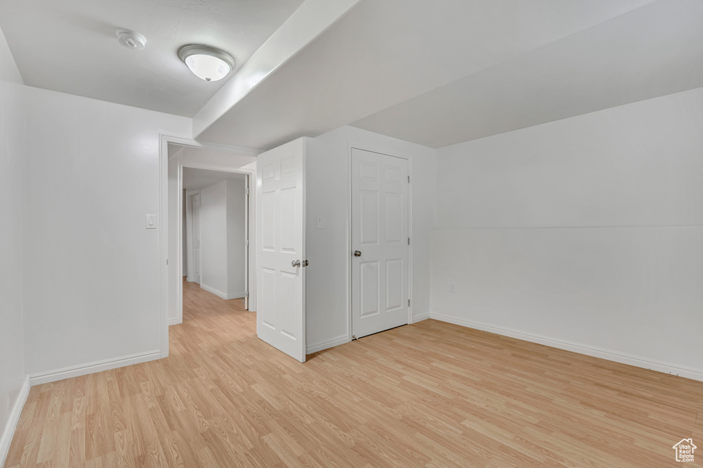 Additional living space with light wood-style floors and baseboards