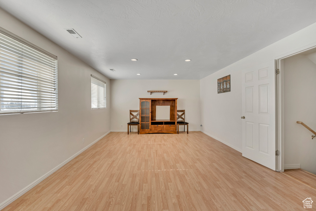 Unfurnished room featuring light wood finished floors, baseboards, and recessed lighting
