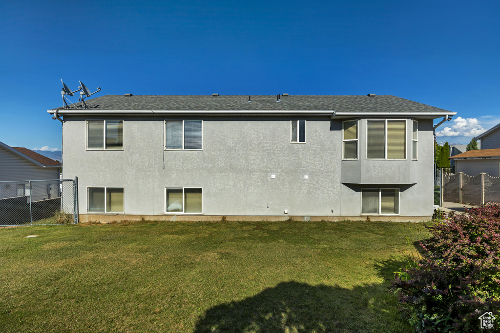 Rear view of property with stucco siding and roof with shingles
