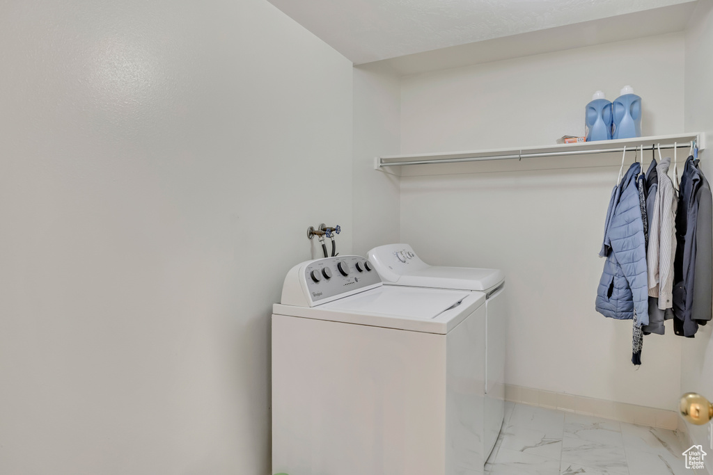 Laundry area with washer and dryer, marble finish flooring, and baseboards