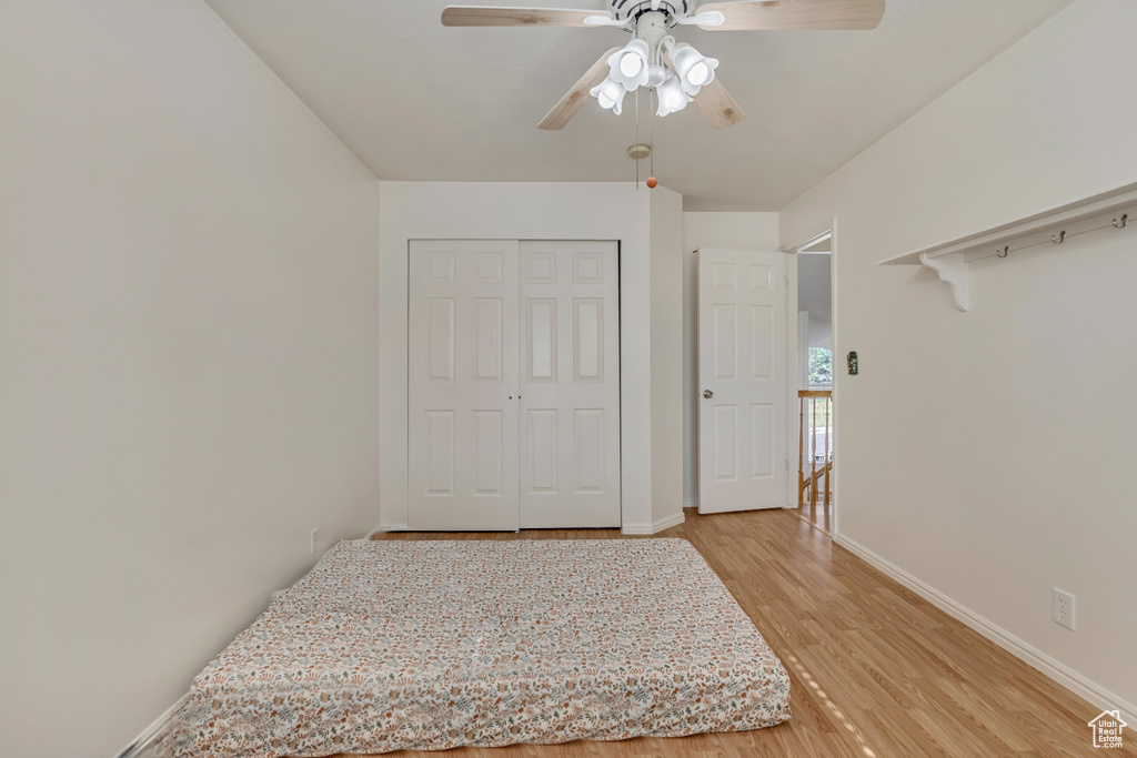 Bedroom featuring light wood-style floors, baseboards, a closet, and a ceiling fan