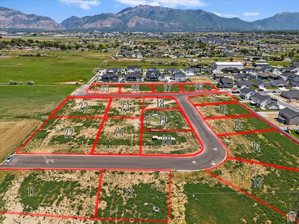Aerial view of residential area with property parcel outlined and a mountainous background
