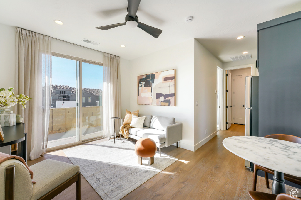 Living room featuring light wood finished floors, ceiling fan, baseboards, and recessed lighting