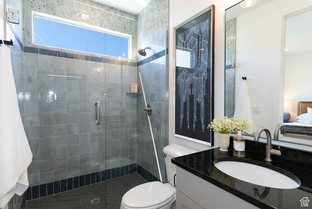 Bathroom featuring a stall shower, vanity, and toilet