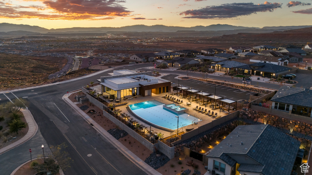 Aerial perspective of suburban area with a mountain backdrop and a pool