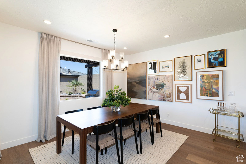 Dining space featuring a chandelier, dark wood-style flooring, baseboards, and recessed lighting