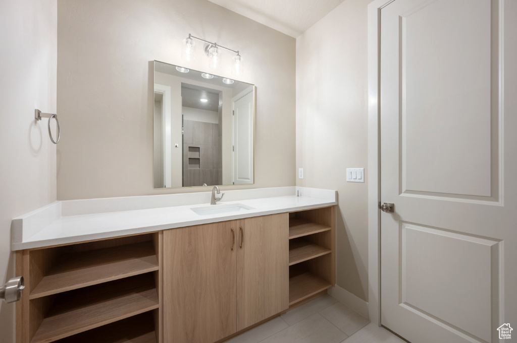 Bathroom with vanity, tile patterned flooring, and baseboards