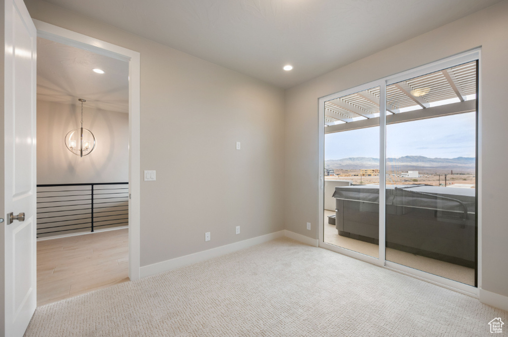 Spare room with carpet floors, recessed lighting, a chandelier, and baseboards