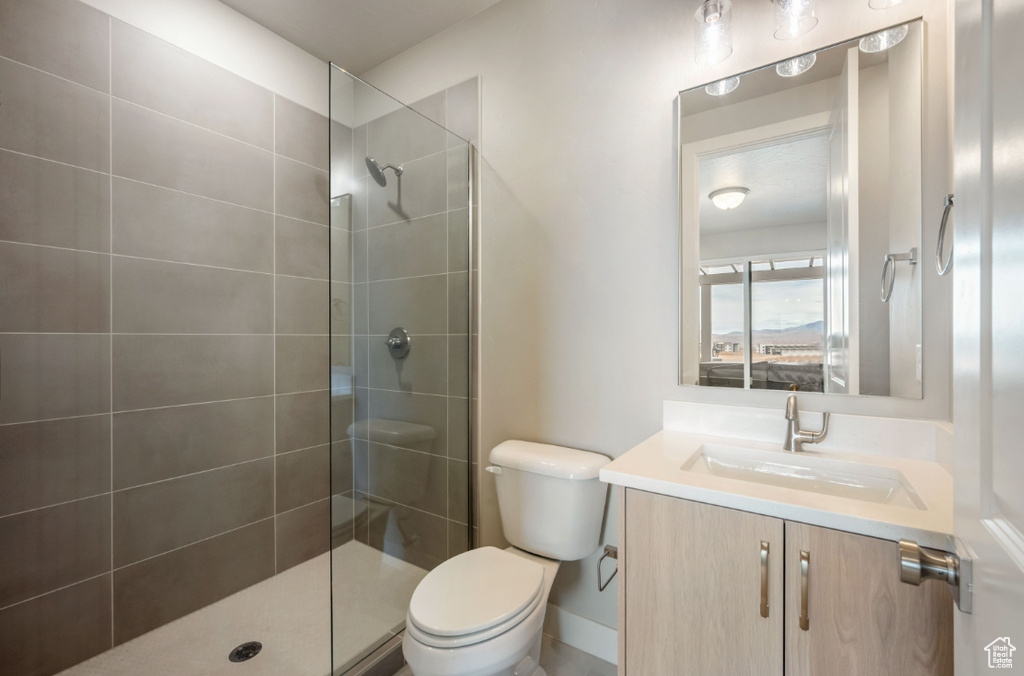 Bathroom with toilet, vanity, walk in shower, and baseboards