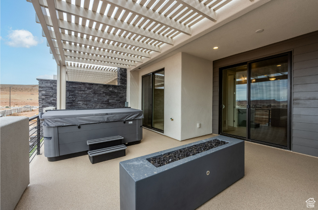 View of patio featuring a fire pit, a hot tub, and a pergola