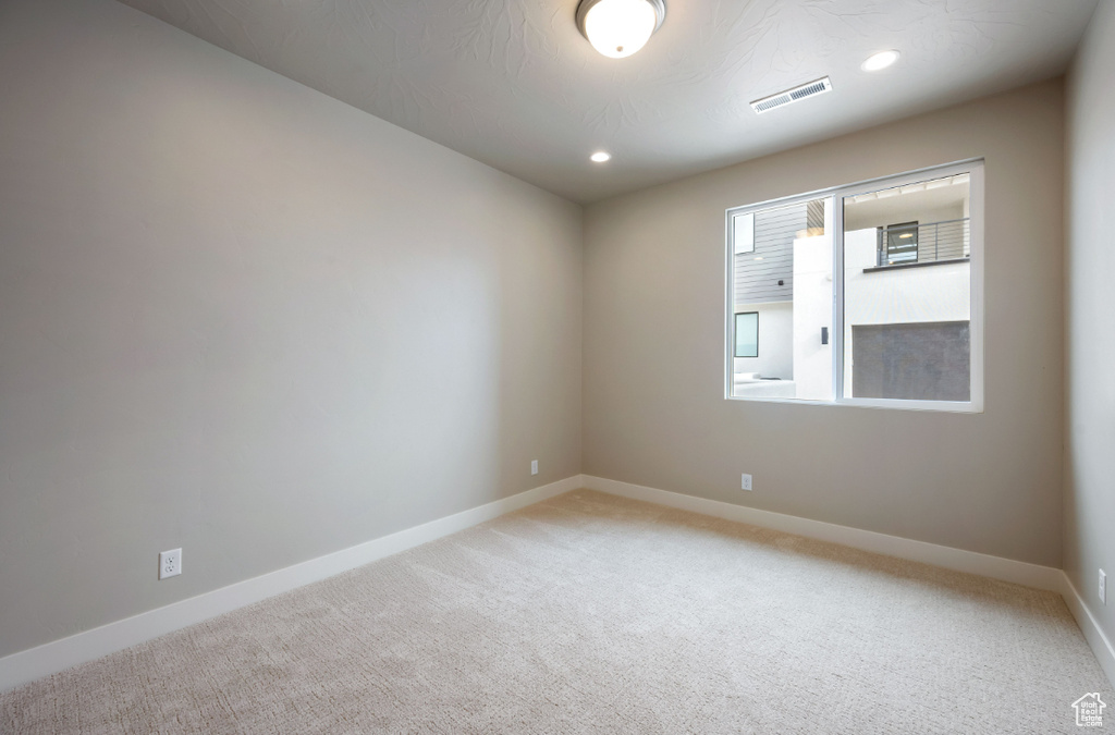 Unfurnished room with light colored carpet, baseboards, and recessed lighting