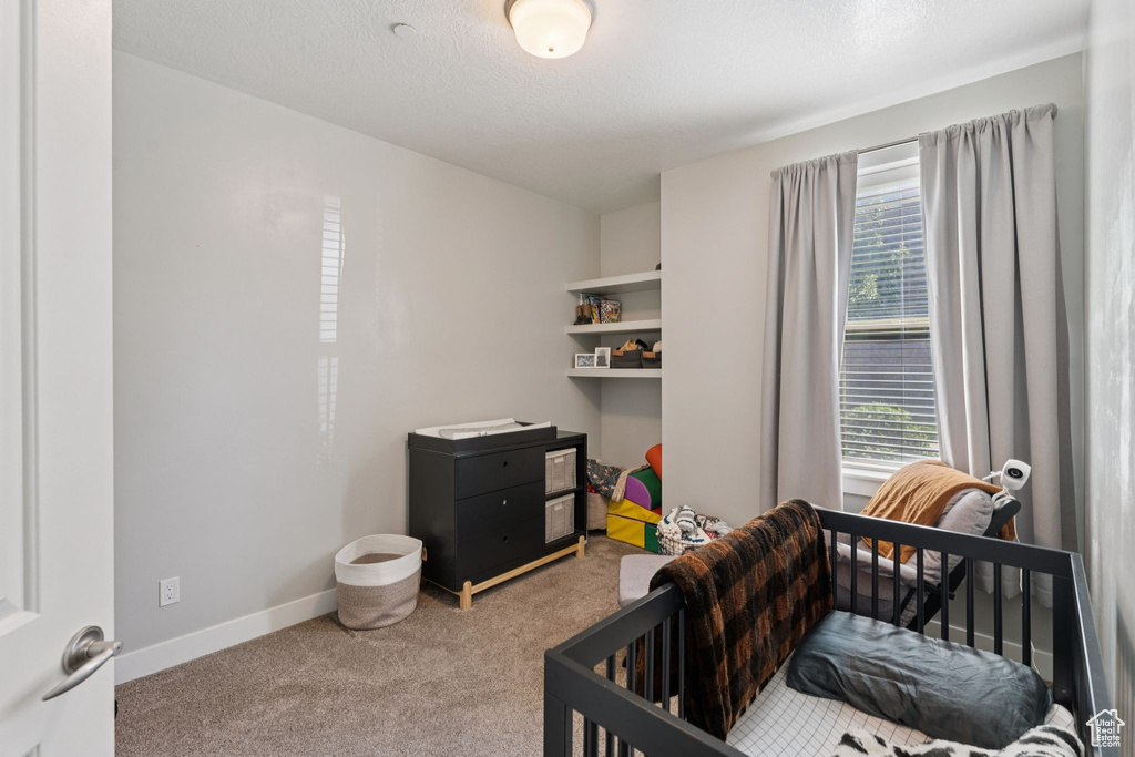 Bedroom featuring carpet and baseboards