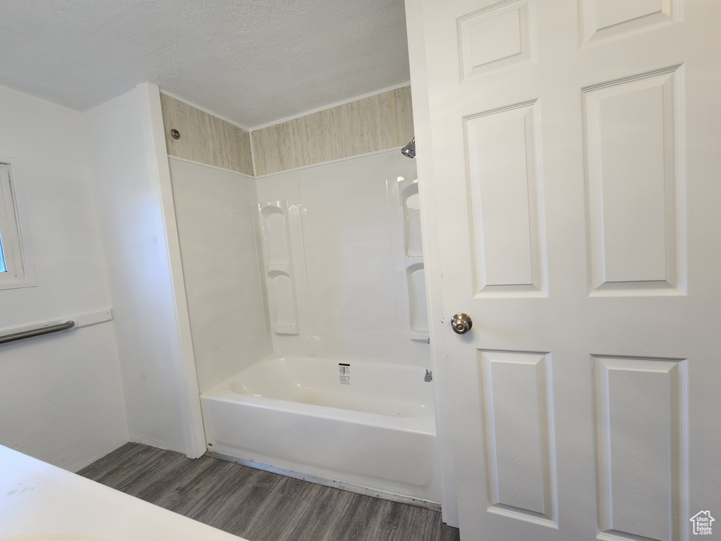 Bathroom featuring wood finished floors and shower / tub combination